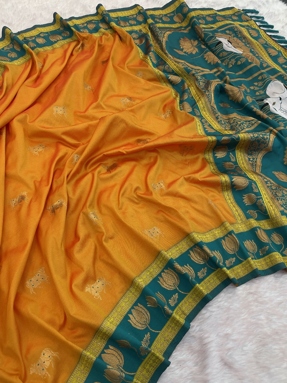 Elegant orange silk Paithani saree for women featuring woven teal border and ethnic lotus motifs.