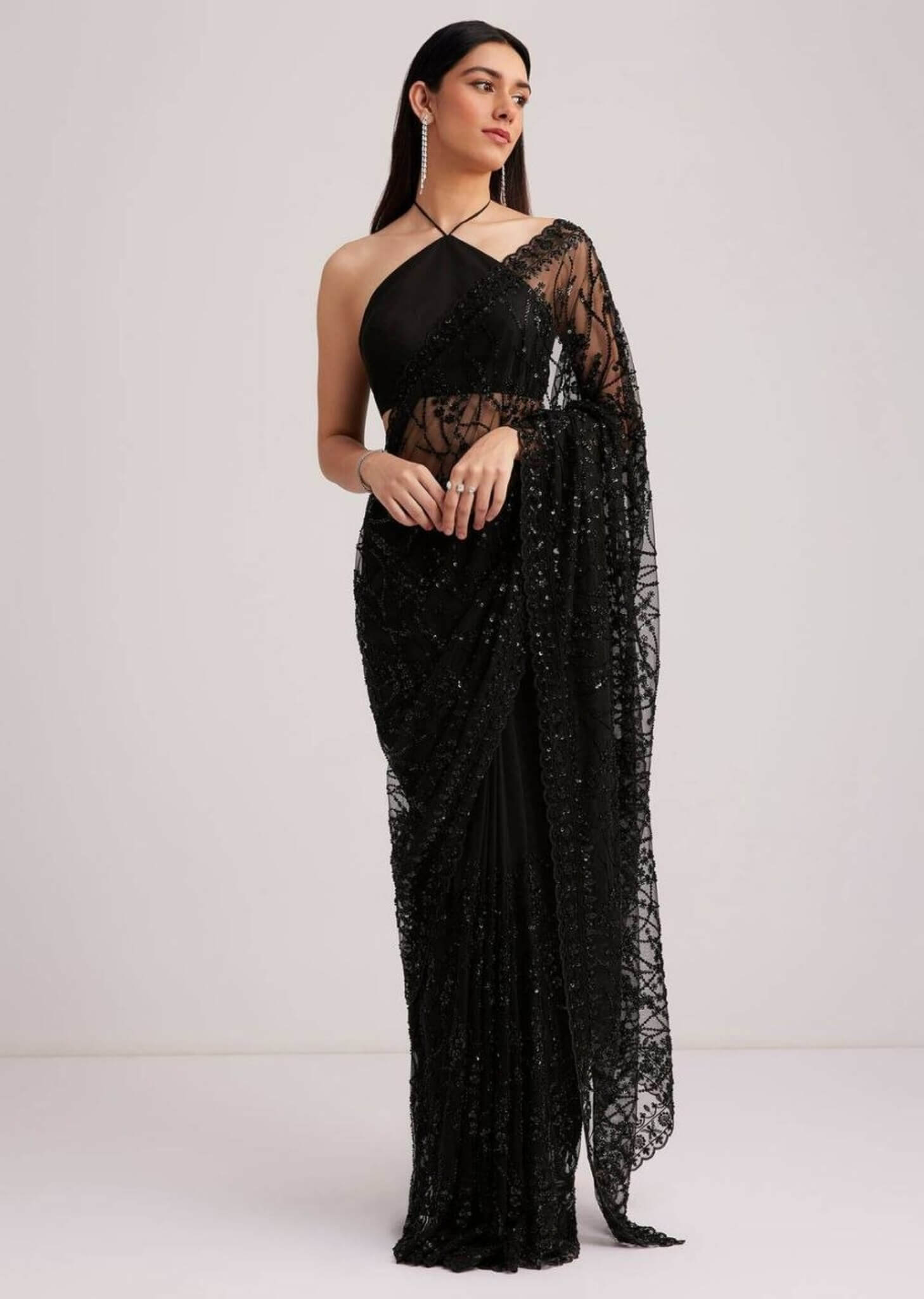 Midnight black net saree with heavy sequin embroidery and matching halter-neck blouse.