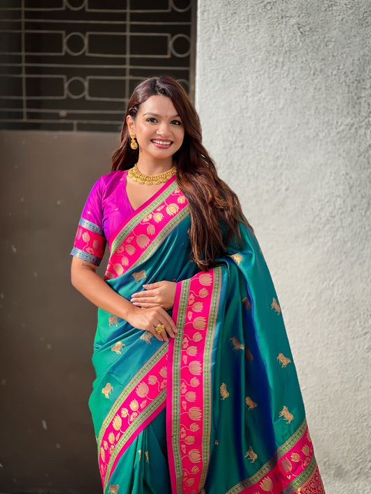 Traditional Maharashtrian Paithani saree in peacock teal with decorative lotus motifs and festive styling.