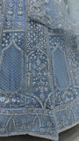Close-up of intricately embroidered blue fabric with silver thread