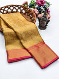Mustard yellow silk saree with an elegant contrasting pink and gold zari border.