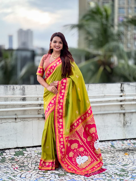 Woman wearing olive green Paithani silk saree with pink lotus zari border and traditional pallu