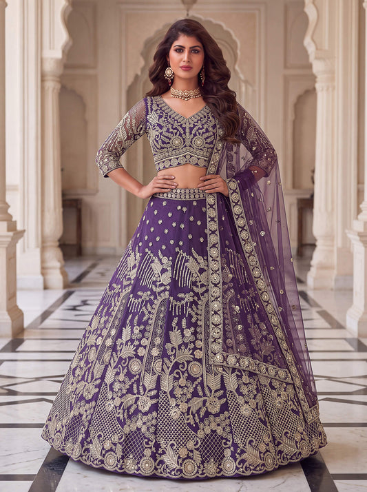 Royal purple net lehenga choli with heavy gold zari embroidery and sheer dupatta.