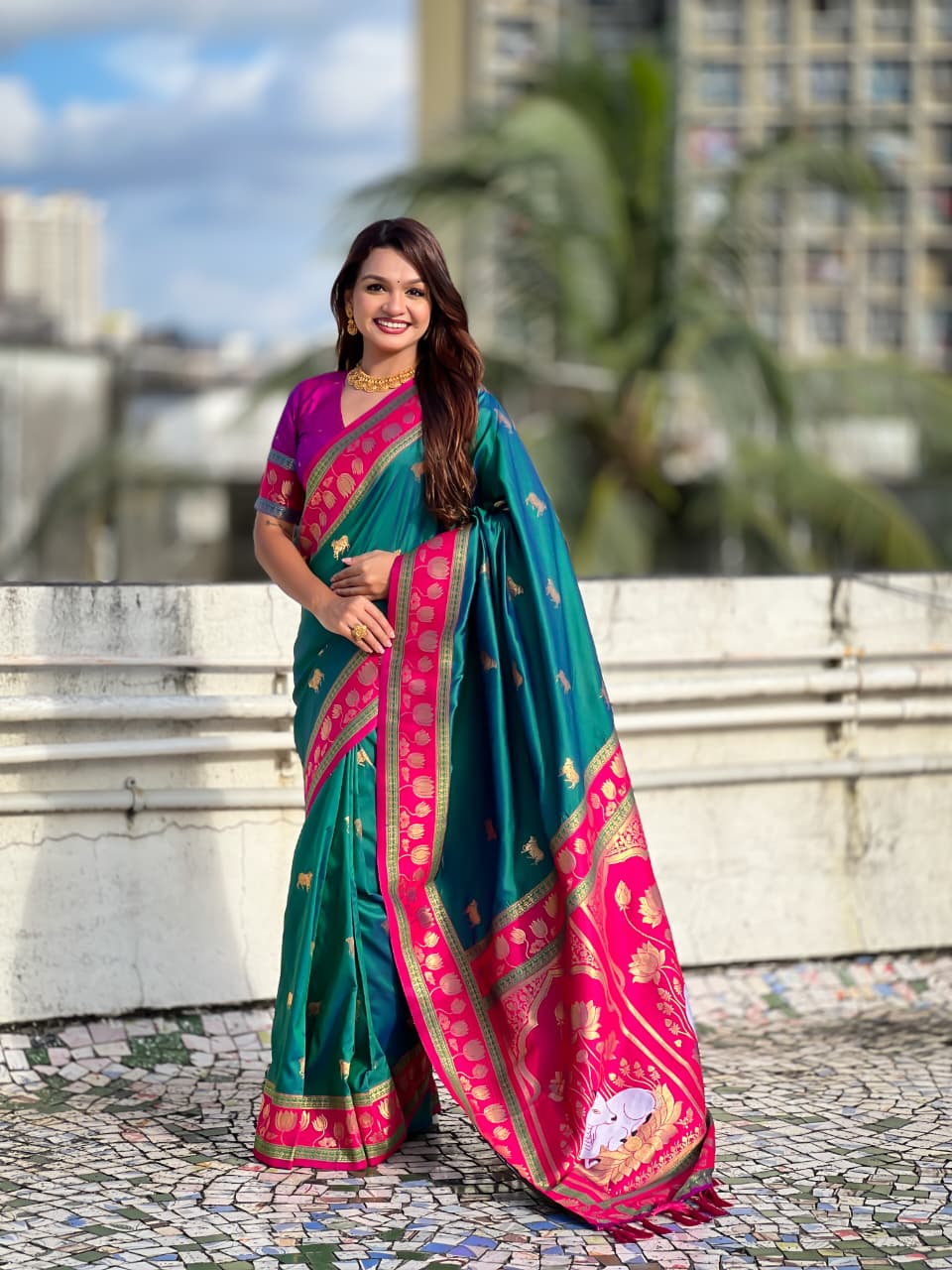 Peacock teal Paithani silk saree with Rani pink lotus zari border and traditional Maharashtrian pallu.