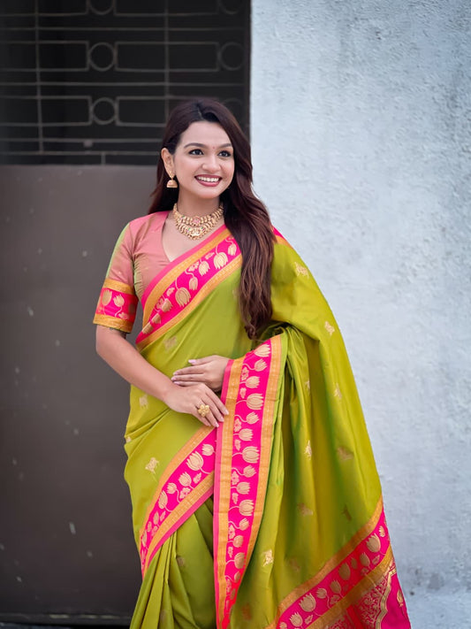 Elegant olive green Paithani saree featuring pink contrast border and woven lotus motifs