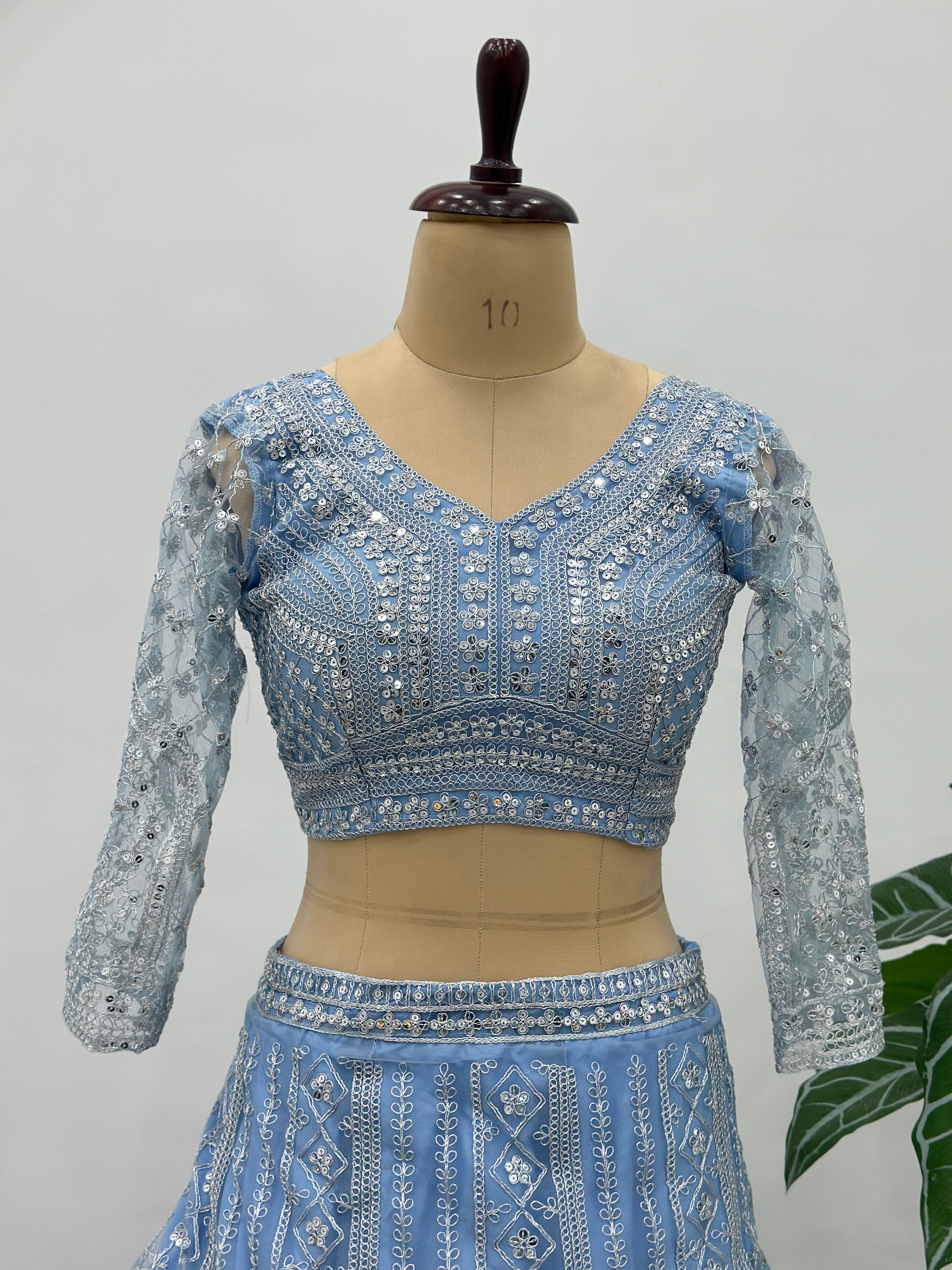 Blue embroidered blouse on a mannequin against a plain background