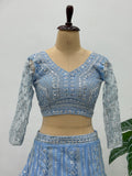 Blue embroidered blouse on a mannequin against a plain background