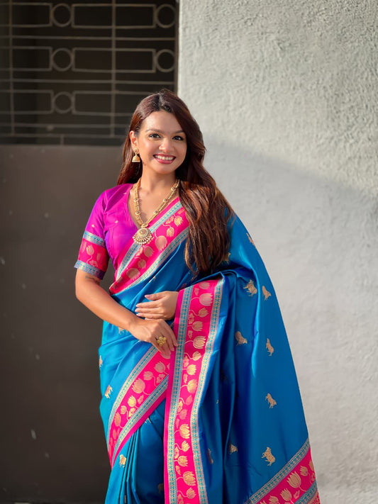 Elegant blue silk Paithani saree featuring pink woven border and intricate heritage motifs for festive occasions.