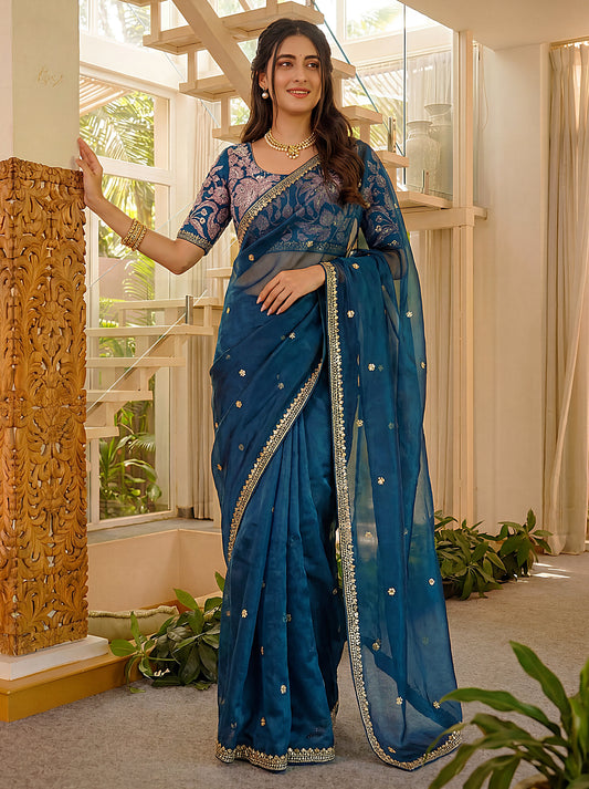 Women wearing teal blue party wear saree with embroidered border work