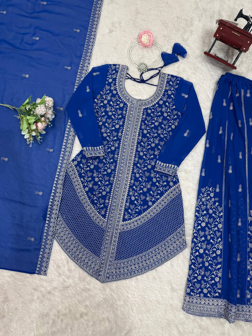Full-length view of a flared sharara bottom paired with a heavily embroidered knee-length blue georgette tunic