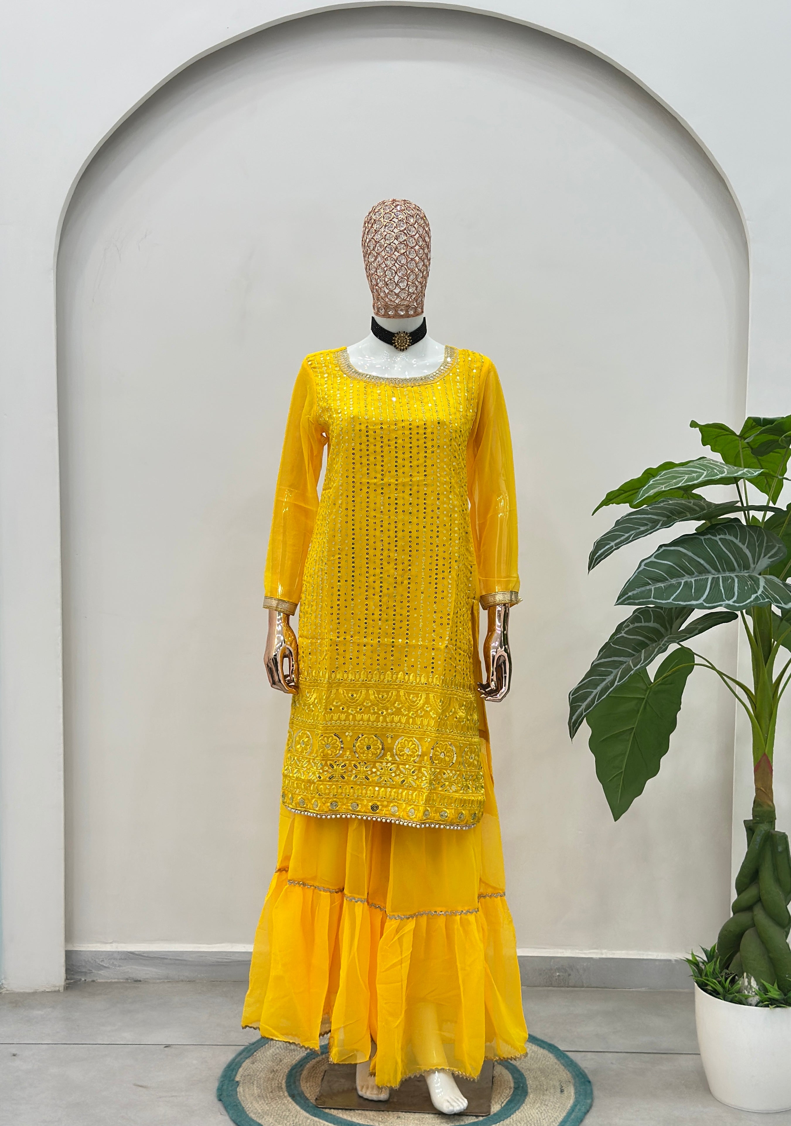 Luxury women’s yellow sharara suit styled with festive jewelry