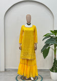 Luxury women’s yellow sharara suit styled with festive jewelry