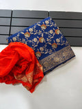 Royal blue pure georgette silk saree laid flat next to a folded bright orange woven blouse piece