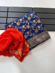 Royal blue pure georgette silk saree laid flat next to a folded bright orange woven blouse piece