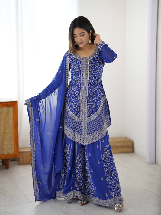 Model wearing a royal blue georgette sharara set with intricate silver floral embroidery and a matching chiffon dupatta