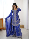 Model wearing a royal blue georgette sharara set with intricate silver floral embroidery and a matching chiffon dupatta